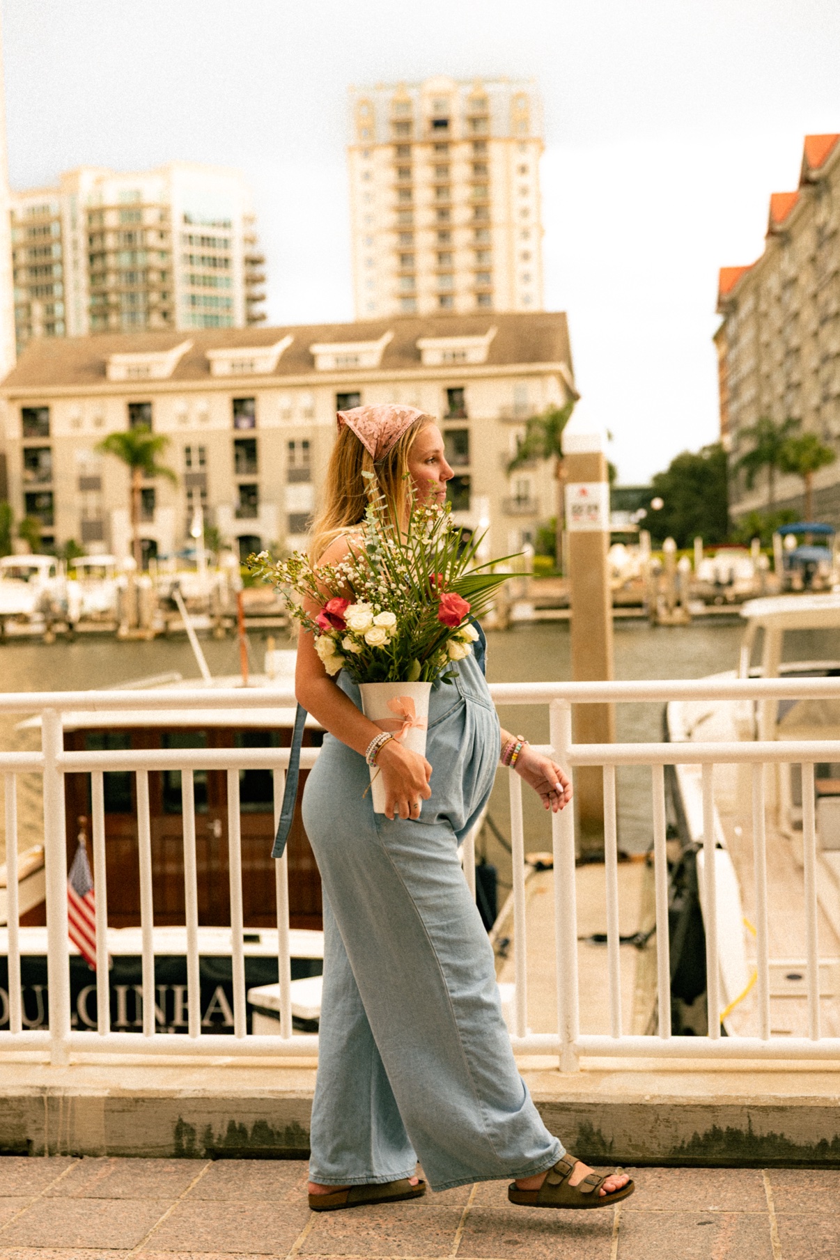 Kai holding a full bouquet on a marina walkway
