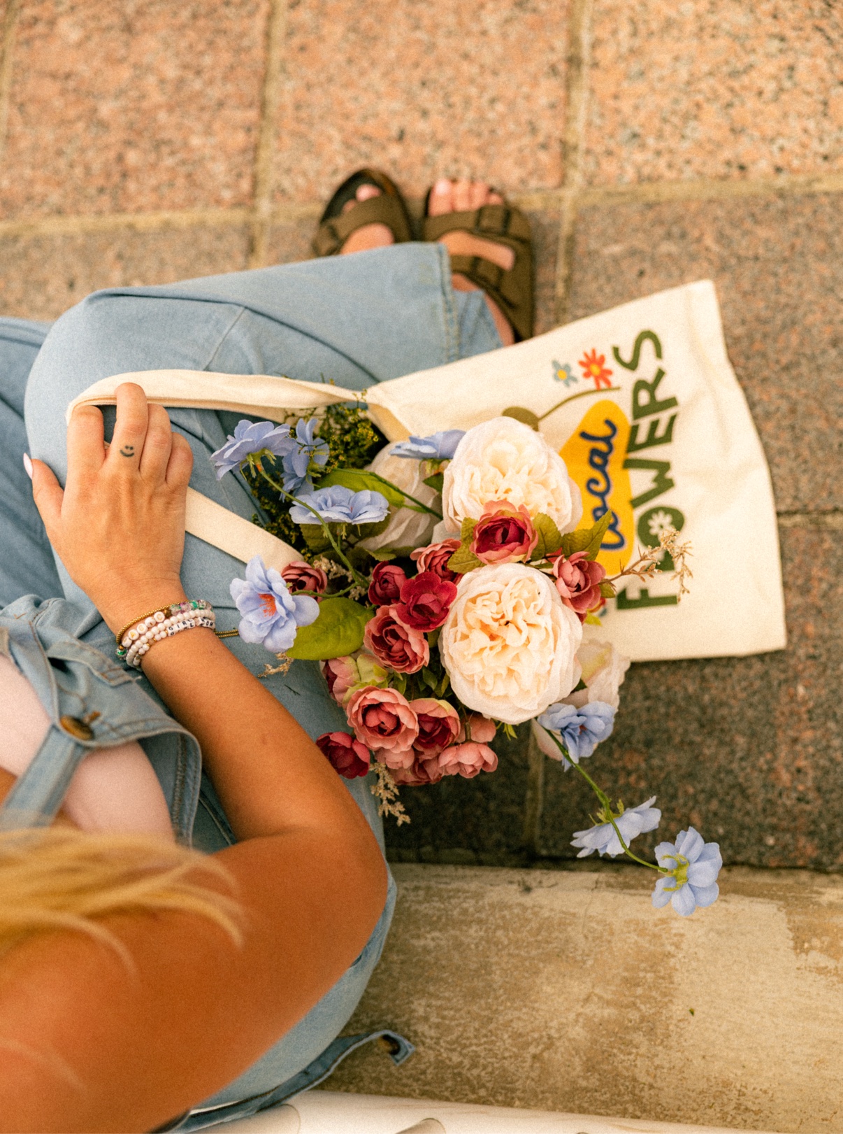 Kai's flower tote and a fresh bouquet laid out on the pavement