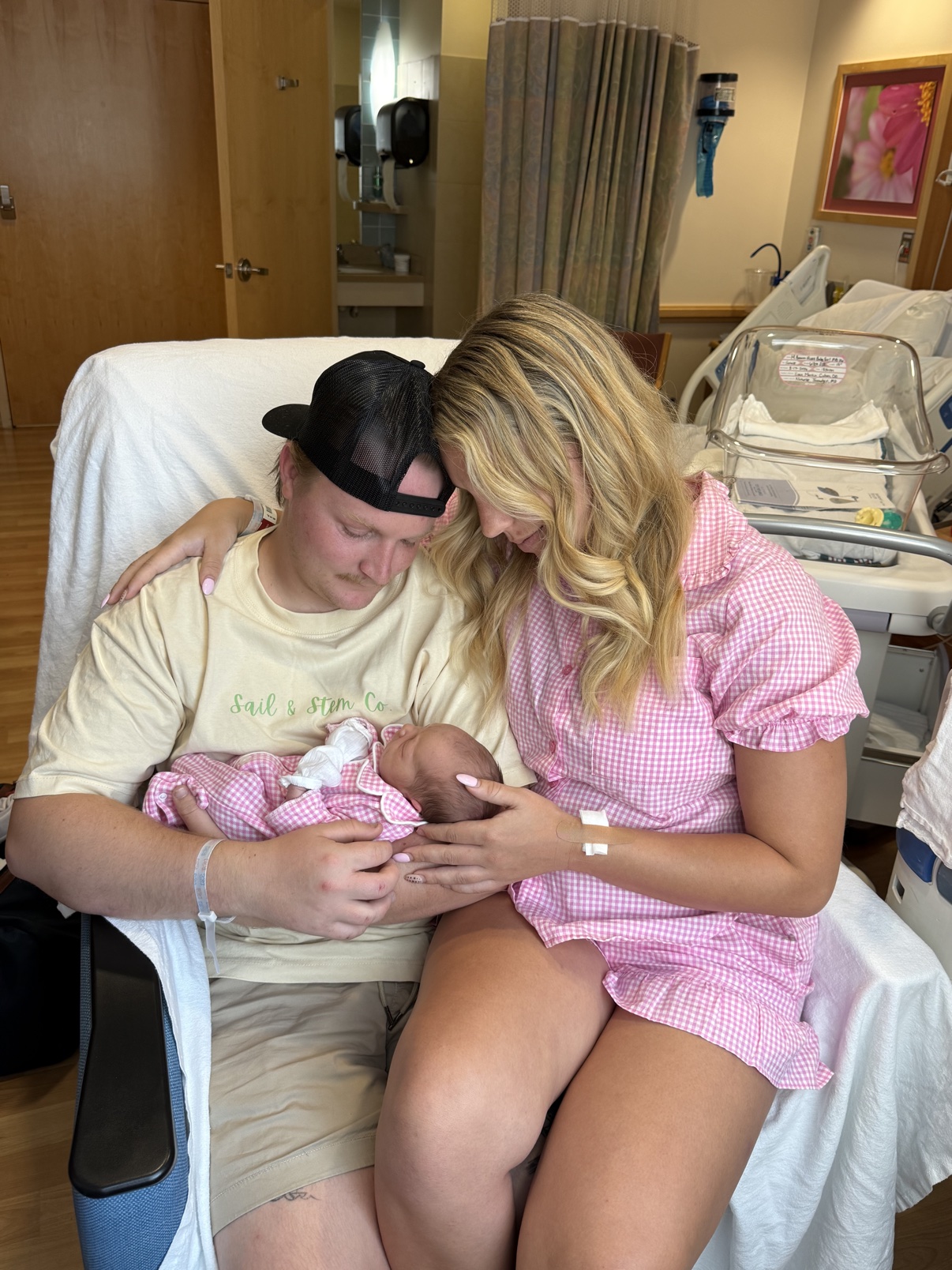 Kai and her husband holding their newborn daughter in the hospital