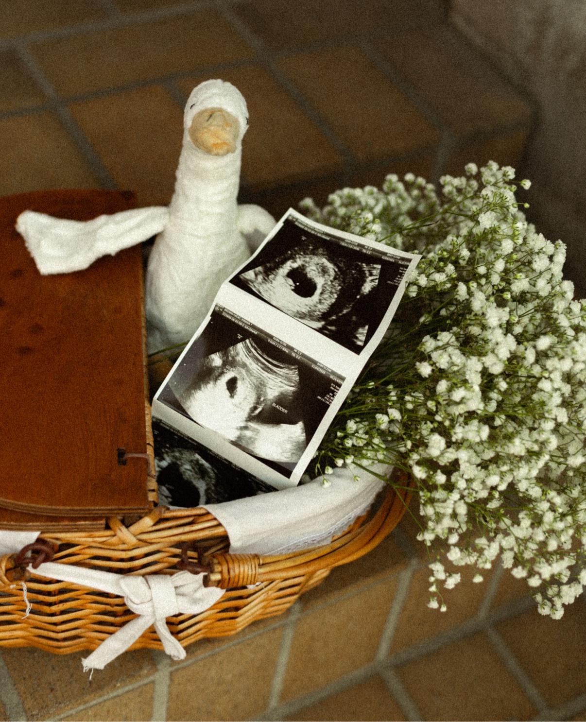 Baby’s breath bouquet arranged with ultrasound photos and a keepsake toy