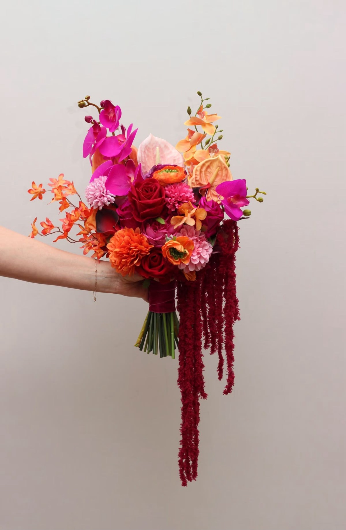Vibrant red, orange, and fuchsia cascading bridal bouquet